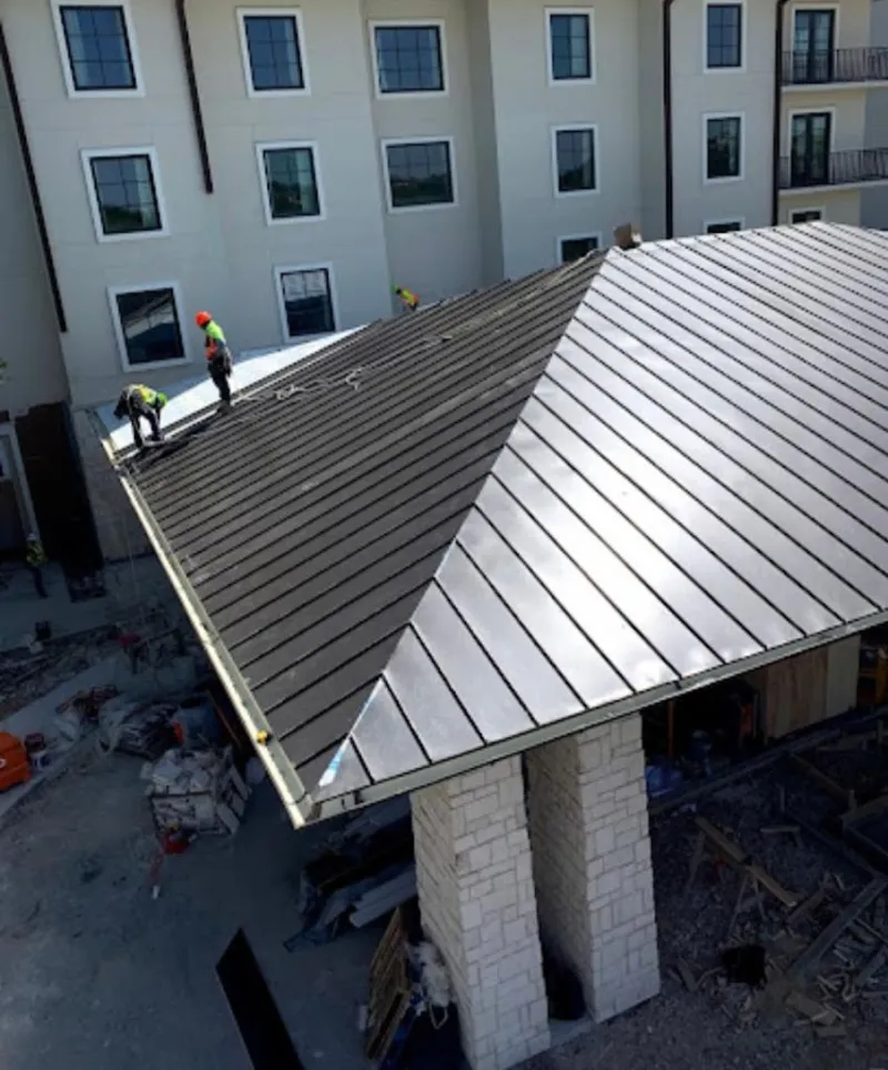Crew installing standing seam metal roof panels on a commercial project in Rockledge
